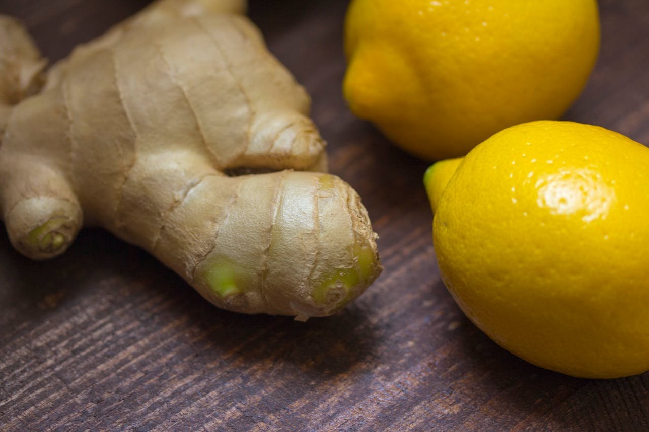 services-04 Close-up of fresh ginger root and lemons on a wooden surface showcasing natural ingredients.