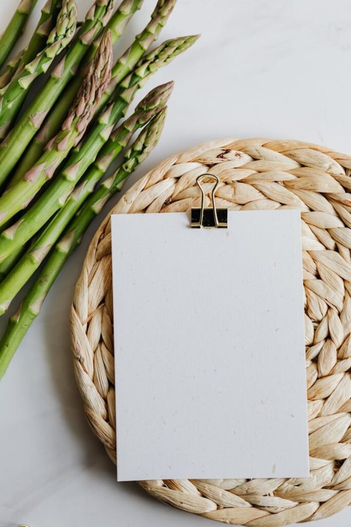 pexels photo 4032978 Top view of fresh asparagus and blank paper on a wicker mat for culinary inspiration.