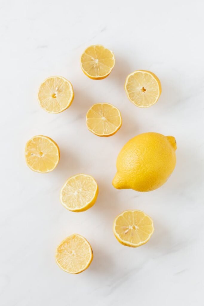 pexels photo 4197821 A flat lay of whole and sliced fresh lemons on a clean marble surface.